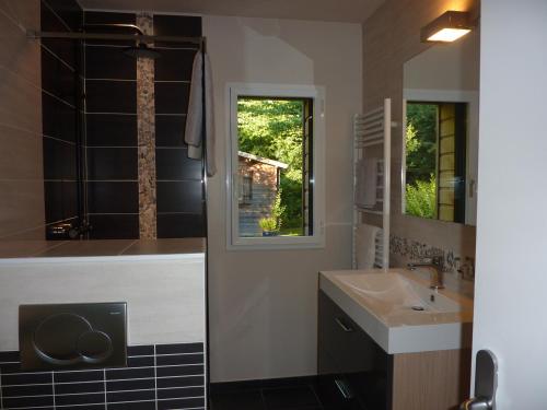 une salle de bain avec une baignoire, un lavabo et un miroir dans l'établissement La Belle Relax - calme et tranquillité assurés - 2 personnes, à Moëlan-sur-Mer