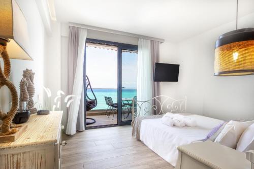 a bedroom with a bed and a view of the ocean at Alkionides Apartments in Polychrono