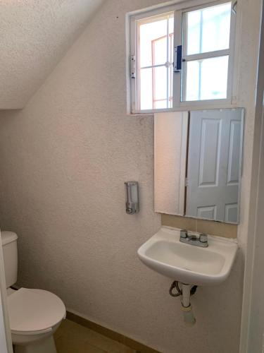 a bathroom with a sink and a toilet and a window at sweet home ixtapa comfort in Ixtapa