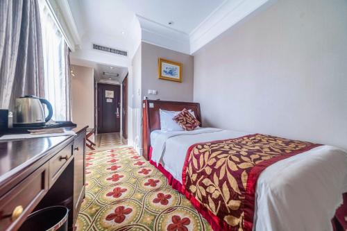 a hotel room with a bed and a television at Ramada Yichang Hotel in Yichang