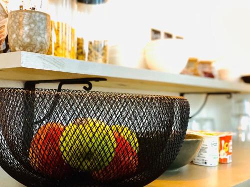 a basket of fruit on a counter in a kitchen at Hotel Le Midi Clermont-Cournon in Cournon-dʼAuvergne