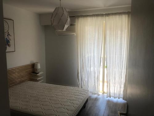 1 dormitorio con cama y ventana grande en 2 pièces Nice Malaussena, en Niza