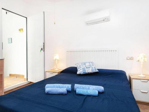 sypialnia z niebieskim łóżkiem z 2 poduszkami w obiekcie Apartamento "SA VIEIRA" BLANES COSTA BRAVA w Blanes