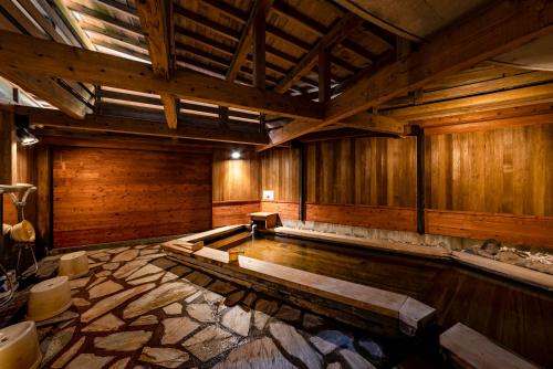 a large room with wooden walls and a swimming pool at ETAVIA Yufuin Kinrinko in Yufuin