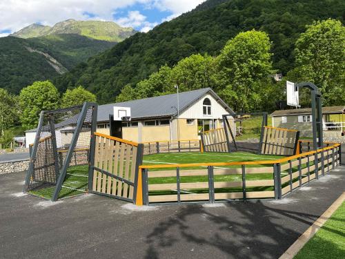 un parque infantil con un tobogán y una valla en Bungalow de 2 chambres avec jardin amenage et wifi a Cauterets, en Cauterets