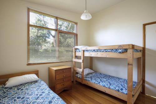 een slaapkamer met 2 stapelbedden en een raam bij Riverview in Anglesea