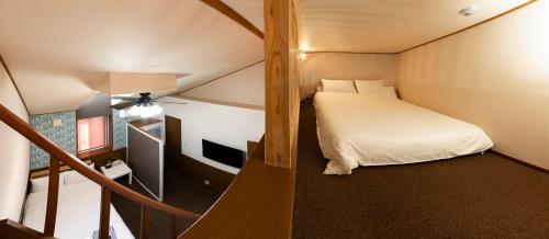 a small room with a bed and a television at ETAVIA Yufuin Kinrinko in Yufuin