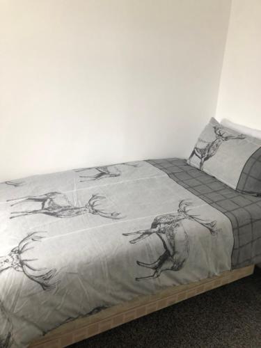 uma cama com um cobertor com desenhos de pássaros em Normanby Raybould house em Normanby