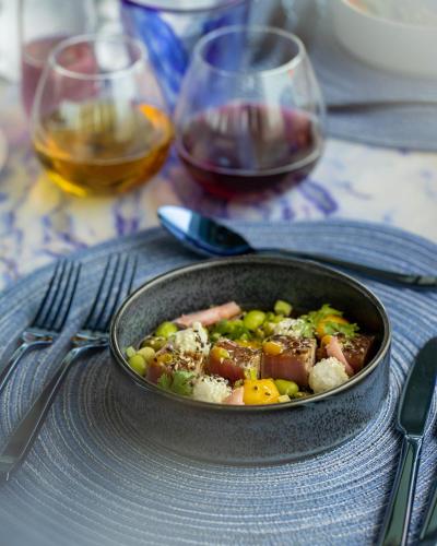 a pan of food on a table with glasses of wine at OBLU SELECT Lobigili - Premium All-Inclusive with Free Transfers in Male City