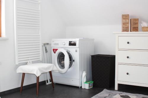 a laundry room with a washing machine and a stool at Ferienhaus Familie Zimmermann in Keutschach am See