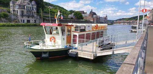 a boat is docked at a dock in a river at Vakantiestudio Ciney in Chapois