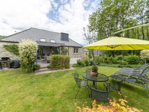 a table with a yellow umbrella in a yard at Charming Cottage in Anseremme with Fenced Garden in Dinant