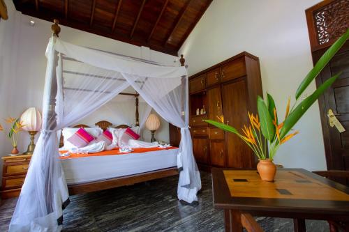 a bedroom with a bed with a canopy at Niyagama House in Galle