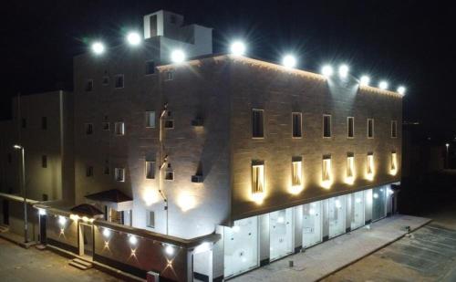 a building with lights on top of it at night at أجنحة عبدالعزيز للوحدات السكنية in Sulţānah