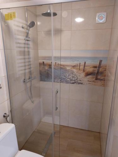 a bathroom with a shower with a painting of a beach at AGROKWATERA STARY DĄB in Czarny Młyn