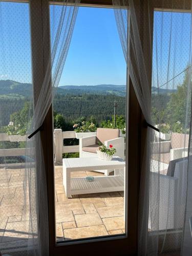 a view from a window of a patio with a couch at Dom pod kogutem in Laliki