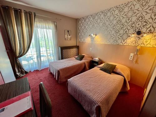 a hotel room with two beds and a window at Hôtel Restaurant le Panorama in Évian-les-Bains