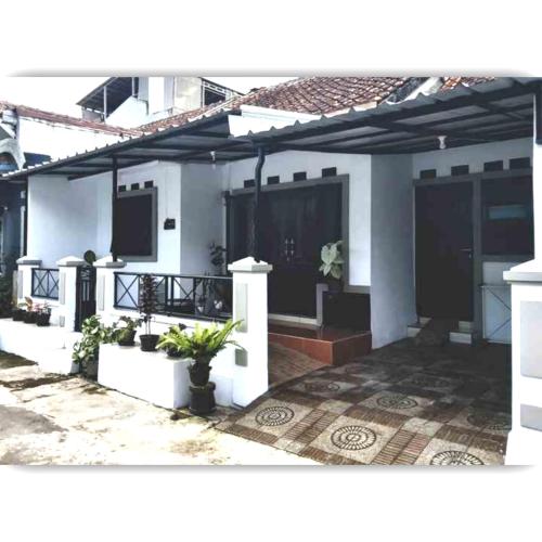 a white house with a patio with plants at Situ Gede Indah HOMESTAY in Tasikmalaya