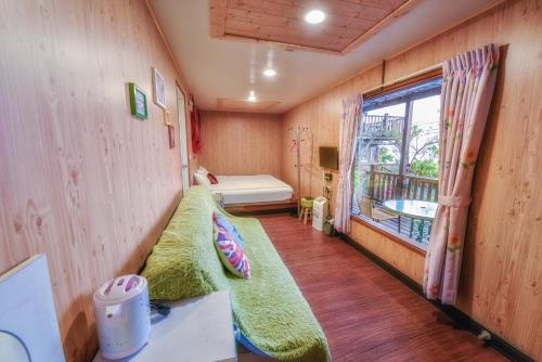 a small room with a bed and a window at Home Box in Renai