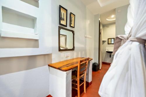 a room with a wooden table and a mirror at Shoestrings Backpackers Lodge Vic Falls in Victoria Falls