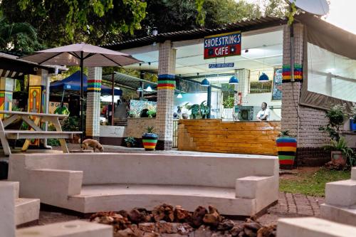 a building with a bench in front of a store at Shoestrings Backpackers Lodge Vic Falls in Victoria Falls