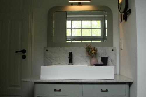 a bathroom with a white sink and a mirror at Landhaus Ankerplatz im Grünen, strandnah , fernab vom mainstream , ideal für Familien in Gorow