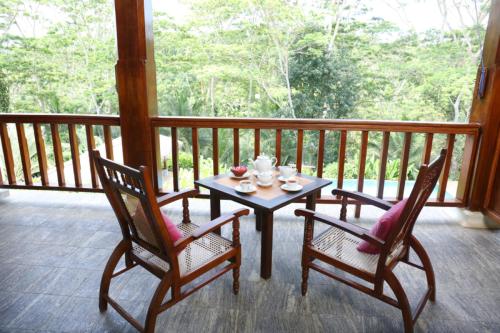 a table and two chairs on a porch at Niyagama House in Galle