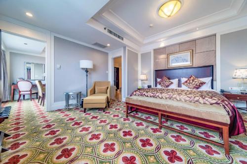 a bedroom with a king sized bed and a chair at Ramada Yichang Hotel in Yichang