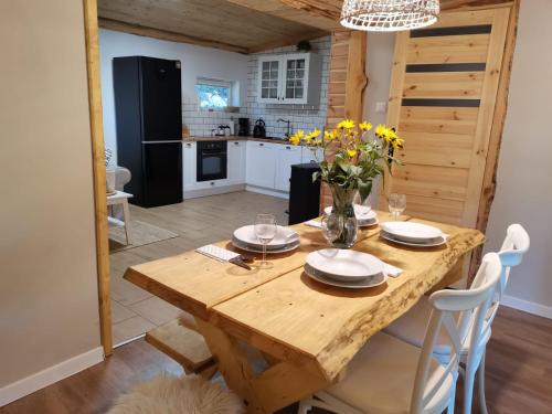 eine Küche und ein Esszimmer mit einem Holztisch in der Unterkunft ACTIVFARM DOMKI NA KASZUBACH Domek Dorotka in Gliśno