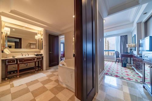 a bathroom with a tub and a large mirror at Ramada Yichang Hotel in Yichang