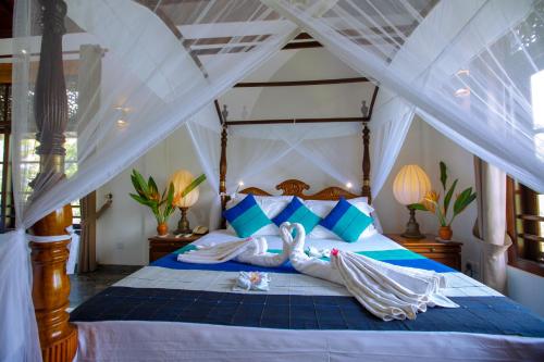a bedroom with two people laying on a bed at Niyagama House in Galle