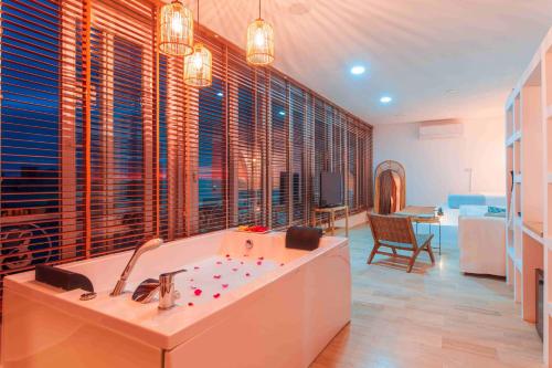 a large bath tub in a room with windows at MARE MARIN BOUTIQUE HOTEL in Bodrum City