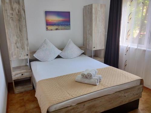 1 dormitorio con 1 cama con 2 toallas en Casa Aura 1, en Costinesti