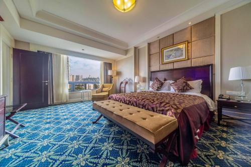 a hotel room with a bed and a large window at Ramada Yichang Hotel in Yichang