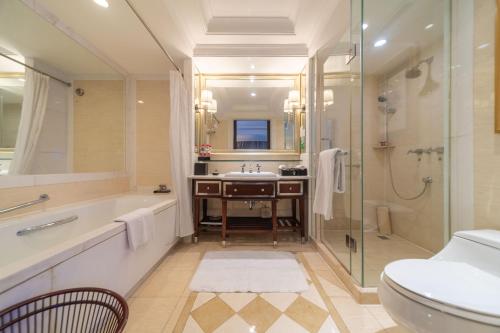 a bathroom with a tub and a sink and a toilet at Ramada Yichang Hotel in Yichang