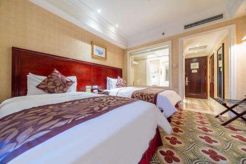 a hotel room with two beds and a window at Ramada Yichang Hotel in Yichang