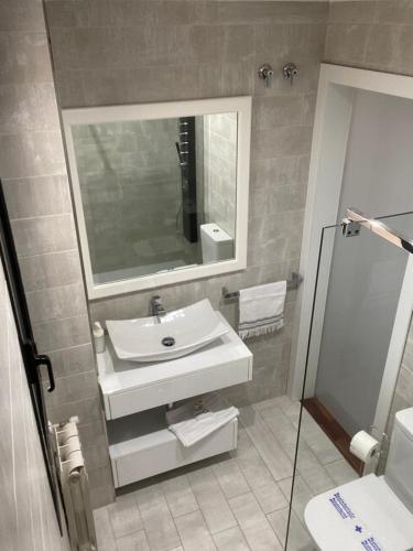 een badkamer met een wastafel en een spiegel bij Descanso Termal in Ourense