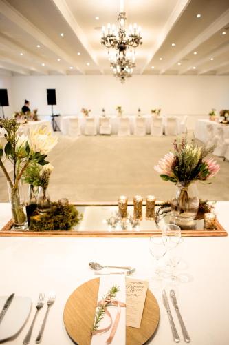 a table set up for a wedding with flowers in vases at Mont d'Or Swartberg Hotel in Prince Albert