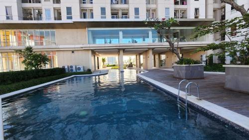 a swimming pool in front of a building at Studio Apartment JiExpo Kemayoran View -Min Stay 3 nights- in Jakarta