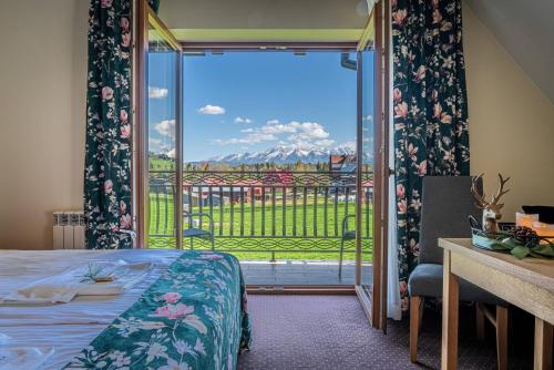 a bedroom with a bed and a sliding glass door at Rezydencja Markowy Dworek in Białka Tatrzańska