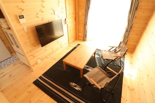 白馬村にあるLog Cottage 白馬KIITOSのリビングルーム(テーブル、椅子、テレビ付)