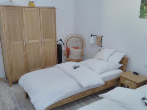 a bedroom with two twin beds and a chair at Das kleine Lavendelhaus in Kahl am Main