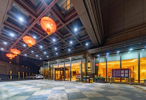 an empty building with orange lanterns in a parking lot at Ramada Yichang Hotel in Yichang