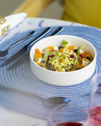 a bowl of soup sitting on a blue plate at OBLU XPERIENCE Ailafushi - All Inclusive with Free Transfers in Male City