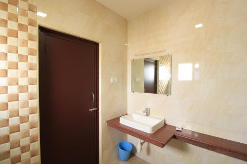a bathroom with a sink and a mirror at Pondy Southern Residency in Puducherry