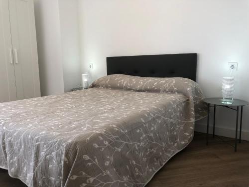 a bedroom with a bed with a blanket on it at Alojamiento Torrevieja playa frente al mar in Torrevieja