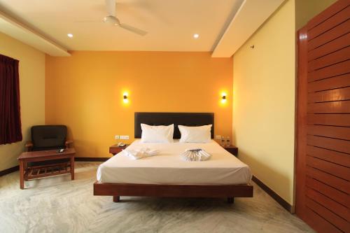 a hotel room with a bed and a chair at Pondy Southern Residency in Puducherry