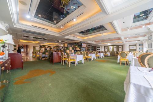a dining room with tables and chairs and books at Ramada Yichang Hotel in Yichang