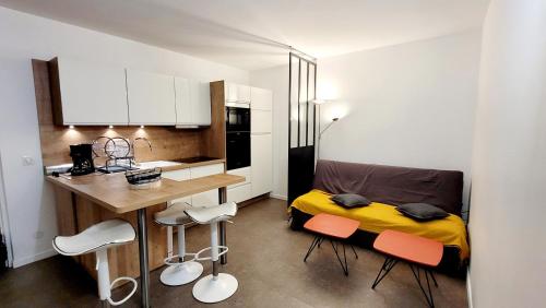 - une petite cuisine avec un lit, une table et des chaises dans l'établissement Comme à la maison!!A 5 min à pied plage,pkg privé, au Grau-du-Roi