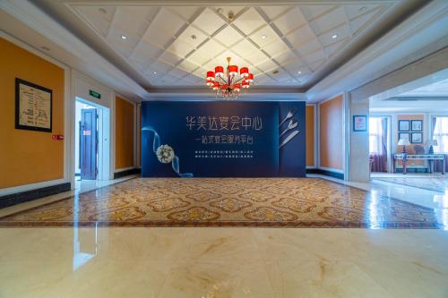 a large room with a blue wall and a chandelier at Ramada Yichang Hotel in Yichang